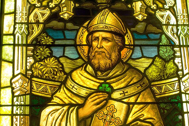 stained glass window depicting st patrick, wearing golden attire